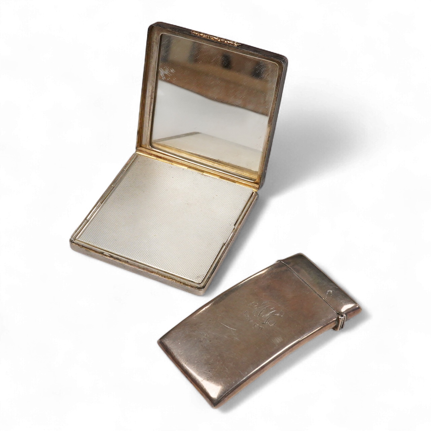 An Elizabeth II engine turned silver and yellow metal square compact, by Mappin & Webb, Birmingham, 1953, 69mm, together with a George V silver concave card case, Birmingham, 1911.